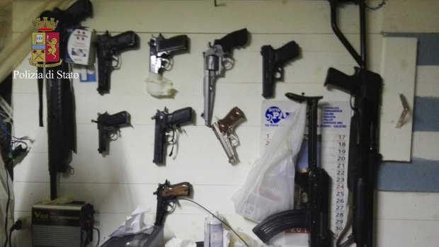In this photo released by the Italian Police, weapons hang on a wall of the hidden bunker where 'Ndrangheta clan bosses Giuseppe Crea and Giuseppe Ferraro were captured.