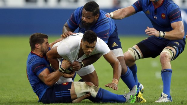 Brought down: England's Luther Burrel is tackled by France's Sebastien Tillous Borde and Mathieu Bastareaud.
