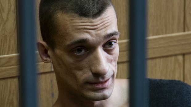 Russian artist Pyotr Pavlensky sits in a cage in court room in Moscow.