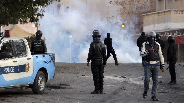 Police forces stand by tear gas during clashes in the city of Ennour, near Kasserine, Tunisia.