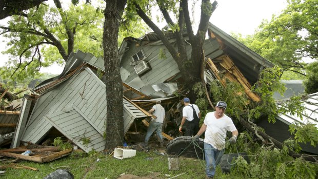 People salvage belongings at a house near Wimberley, Texas.
