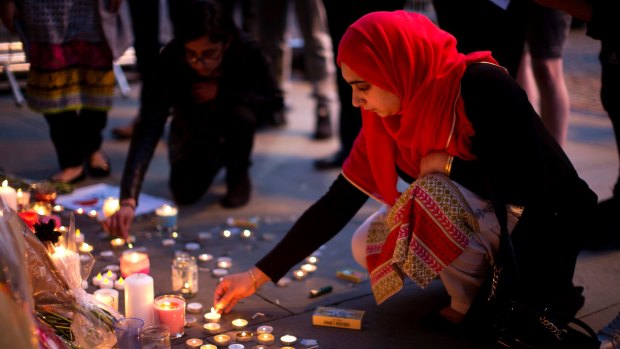 Female solidarity: A woman lights candles after a vigil in Albert Square, Manchester.