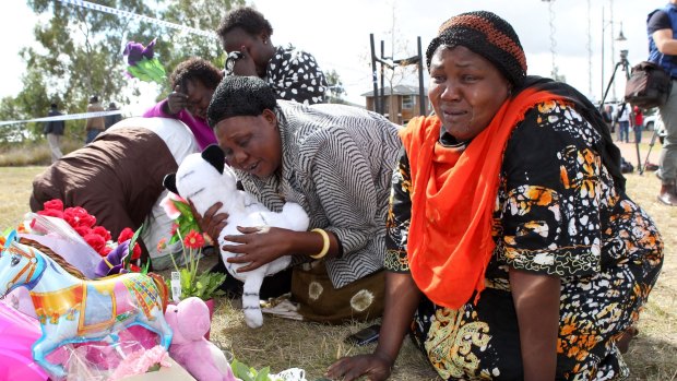 Members of the local Sudanese community grieve at the scene in Wyndham Vale.