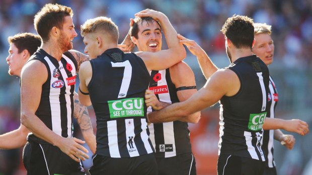Steele Sidebottom of the Magpies celebrates a goal with teammates.
