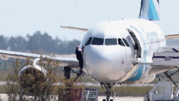 A man leaves the hijacked aircraft of Egyptair from a pilot window.