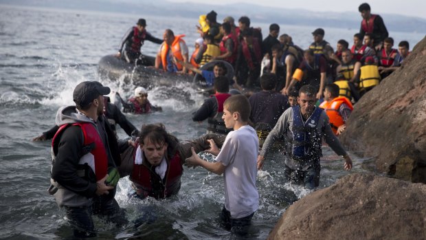 Refugees arrive on a dinghy after crossing from Turkey to Lesbos island, Greece.