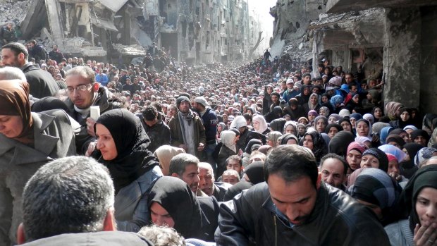 Residents of the besieged Palestinian camp of Yarmouk, queuing to receive food supplies, in Damascus, Syria in January. Last week, Islamic State militants infiltrated the camp. 