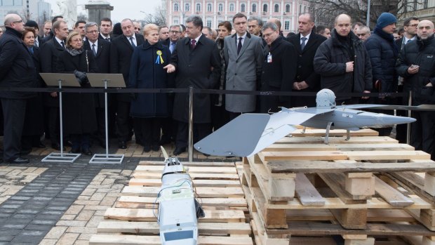 Ukrainian President Petro Poroshenko, centre, in front of Russian-made spy drones apparently seized by Ukrainian troops in eastern Ukraine.