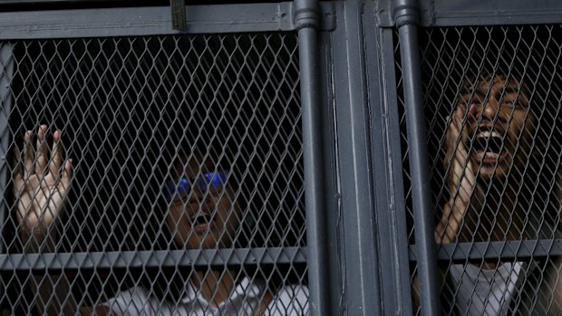 Demonstrators shout from a police van after they were detained during Saturday's protest in Kuala Lumpur.