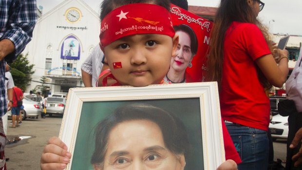 A boy holds a portrait of Myanmar's State Counsellor Aung San Suu Kyi during a rally to show support for her in Yangon.