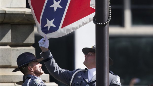 An honour guard from the South Carolina Highway patrol lowers the Confederate battle flag as it is removed from the Capitol grounds  in Columbia, South Carolina. 