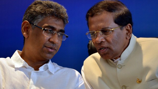Sri Lanka's main opposition presidential candidate Maithripala Sirisena, right, listens to Investment Promotion Deputy Minister Faizer Mustapha at a press conference in Colombo on Wednesday. 