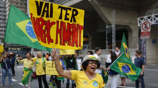 A demonstrator holds a banner that reads in Portuguese "There will be Impeachment" during an anti-Rousseff protest on Monday.