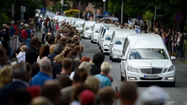 Students from the Joseph-Koenig-Gymnasium watch as hearses carrying the remains of 16 of their fellow students and two teachers who were killed in the Germanwings plane crash in March drive slowly past on Wednesday.