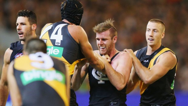 Sam Docherty of the Blues wrestles with Ben Griffiths of the Tigers (left) and Kane Lambert.