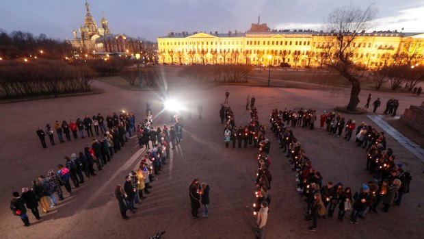 People form a 14.40 - the time of the attack - in memory of victims of the subway bombing in St Petersburg, Russia.