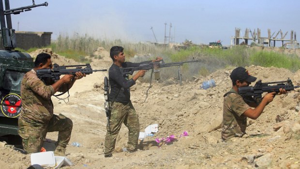 Iraqi security forces fire at Islamic State militants in Fallujah.