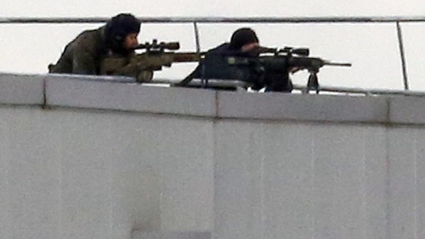 Before the assault ... French special forces take position with sniper rifles on the rooftop of a complex at an industrial building in Dammartin-en-Goele, northeast of Paris.