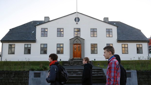 People walk past the Icelandic Prime Minister's office in Reykjavik.