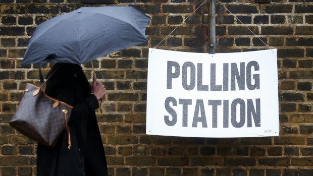 A pedestrian walks past a sign for a polling station in London on Thursday.