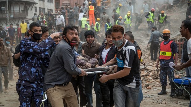 Emergency rescue workers carry a victim on a stretcher after Dharara tower collapsed in Kathmandu, Nepal. 