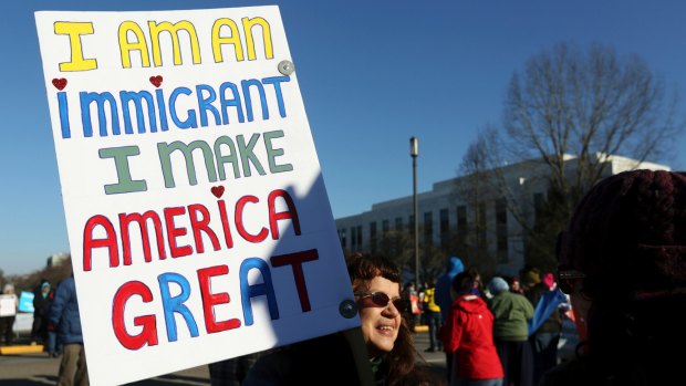 A protester carries a sign during an immigrant rights rally at the Oregon State Capitol in Salem in January.