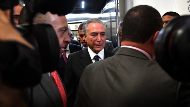 Brazilian interim President Michel Temer leaves the Rio 2016 main press centre under heavy security after a brief visit on Thursday. 
