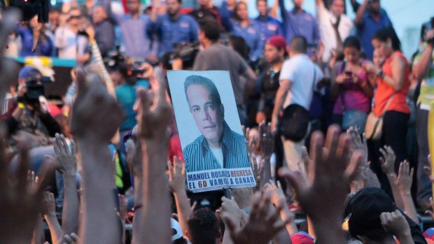 A poster of Venezuelan opposition leader Manuel Rosales in a crowd of supporters waiting for his return from exile, in Maracaibo, Venezuela, last week.