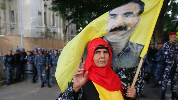 A Kurdish demonstrator holds a flag with a portrait of jailed Kurdish leader Abdullah Ocalan, during a protest against the operation by the Turkish army, outside the Russian embassy in Beirut.