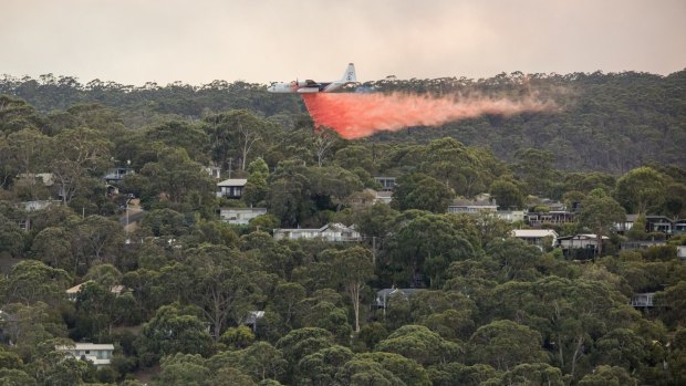 A waterbomber sprays fire retardent on the outskirts of Lorne on Christmas Day.