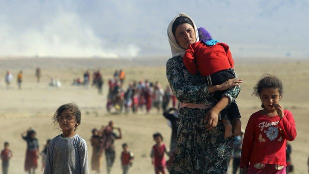 Here displaced people from the Yazidi sect flee the Islamic State in Sinjar, Iraq. Amnesty has accused governments of "pretending the protection of civilians is beyond their power."