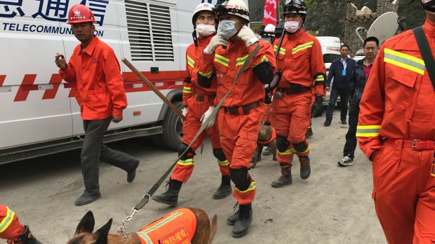 Rescuers with search dogs near the site of the Xinmo landslide in south-western China's Sichuan Province.