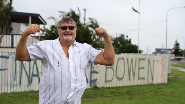 Graham Wilson paints a fresh message on his fence in the wake of Cyclone Debbie.