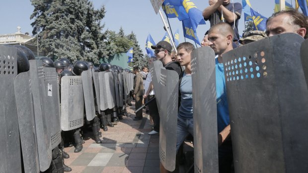 Protesters (right) face Ukraine riot police after parliament gave preliminary approval to a controversial constitutional amendment to provide greater powers to separatist regions in the east. 