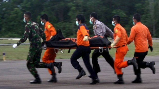 Rescue personnel unload body bags containing bodies recovered from the underwater wreckage of AirAsia flight QZ8501. 