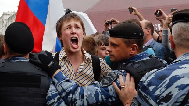 A young protestor shouts out as he is blocked during a demonstration in downtown Moscow.