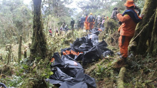 A rescue team member stands near bodies of the victims of the crashed Trigana Air plane, at the crash site near Oksibil, Bintang Mountains district, Papua province, Indonesia, in August.