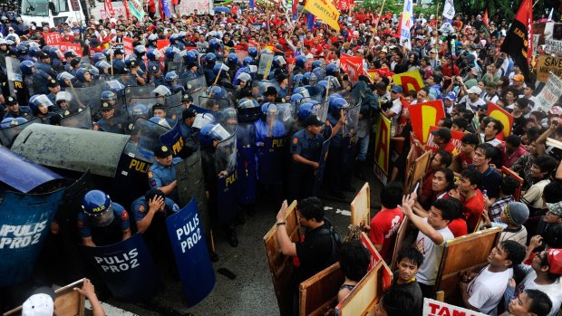 Thousands of anti-government protesters clash with riot police during their march towards the House of Representative to coincide with Benigno Aquino III's address.