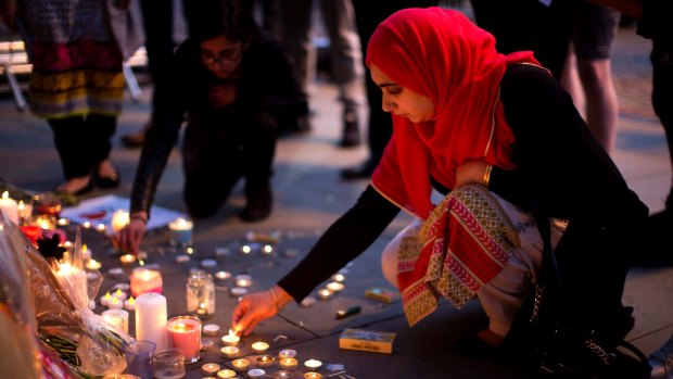 Female solidarity: A woman lights candles after a vigil in Albert Square, Manchester.
