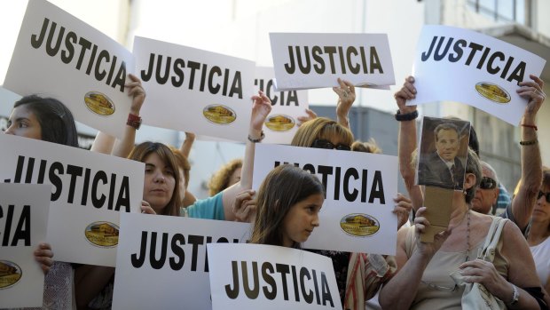 People hold placards that read "Justice"  during a rally in front of the headquarters of the AMIA (Argentine Israelite Mutual Association), in Buenos Aires.