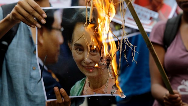 Reputation going up in flames: activists burn a poster of Aung San Suu Kyi.