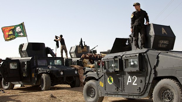 Iraqi special forces soldiers - flying a sectarian Shiite flag from their vehicles - move out to join the Mosul offensive from a camp near Khazer, Iraq, on Friday. 