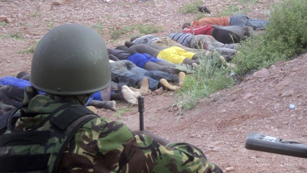36 dead ... A Kenyan soldier looks over the bodies of non-Muslim quarry workers executed by Somalian Islamists in north-east Kenya.