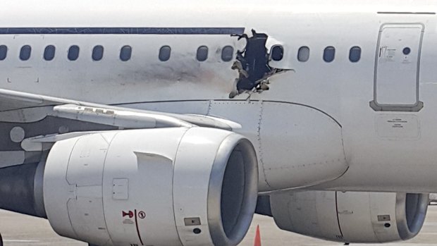 The plane operated by Daallo Airlines sits on the runway in Mogadishu. A gaping hole in the commercial airliner forced it to make an emergency landing in Somalia's capital.