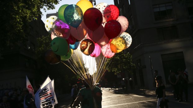 A balloon seller walks past people on the way to the closing rally of presidential candidate Alejandro Guillier in Santiago.