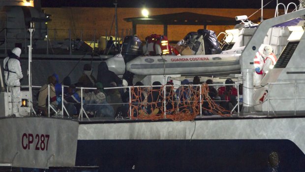 Migrants arrive at Lampedusa harbour early on Sunday.