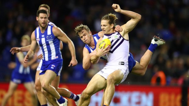 Nat Fyfe of the Dockers is tackled by Trent Dumont of the Kangaroos during Sunday's match at Etihad Stadium.