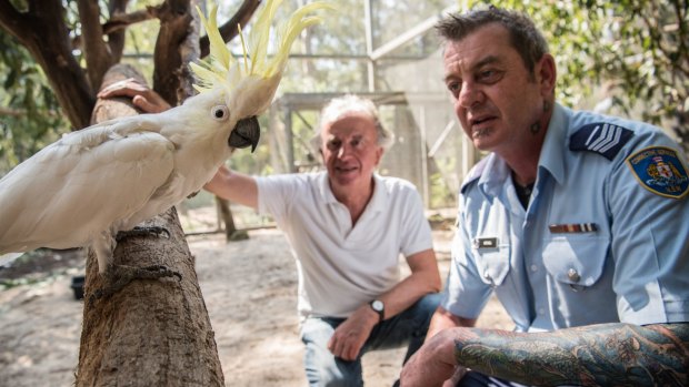 Correctional Officer Ian Mitchell and reporter Hamish McDonald with George the Cockatoo.