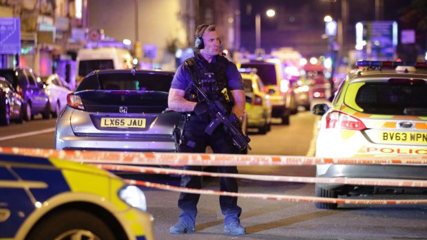 An armed police officer mans a cordon on the Seven Sisters Road at Finsbury Park.