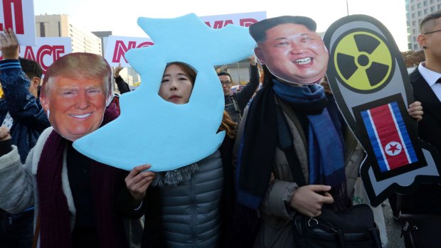 Anti-war protesters wearing cutouts of US President Donald Trump and North Korean leader Kim Jong-un, march demanding peace on the Korean peninsula near the American Embassy in Seoul on Sunday.
